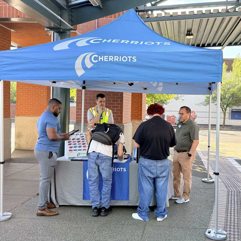 Microtransit Outreach Event - folks gathered around a Cherriots table